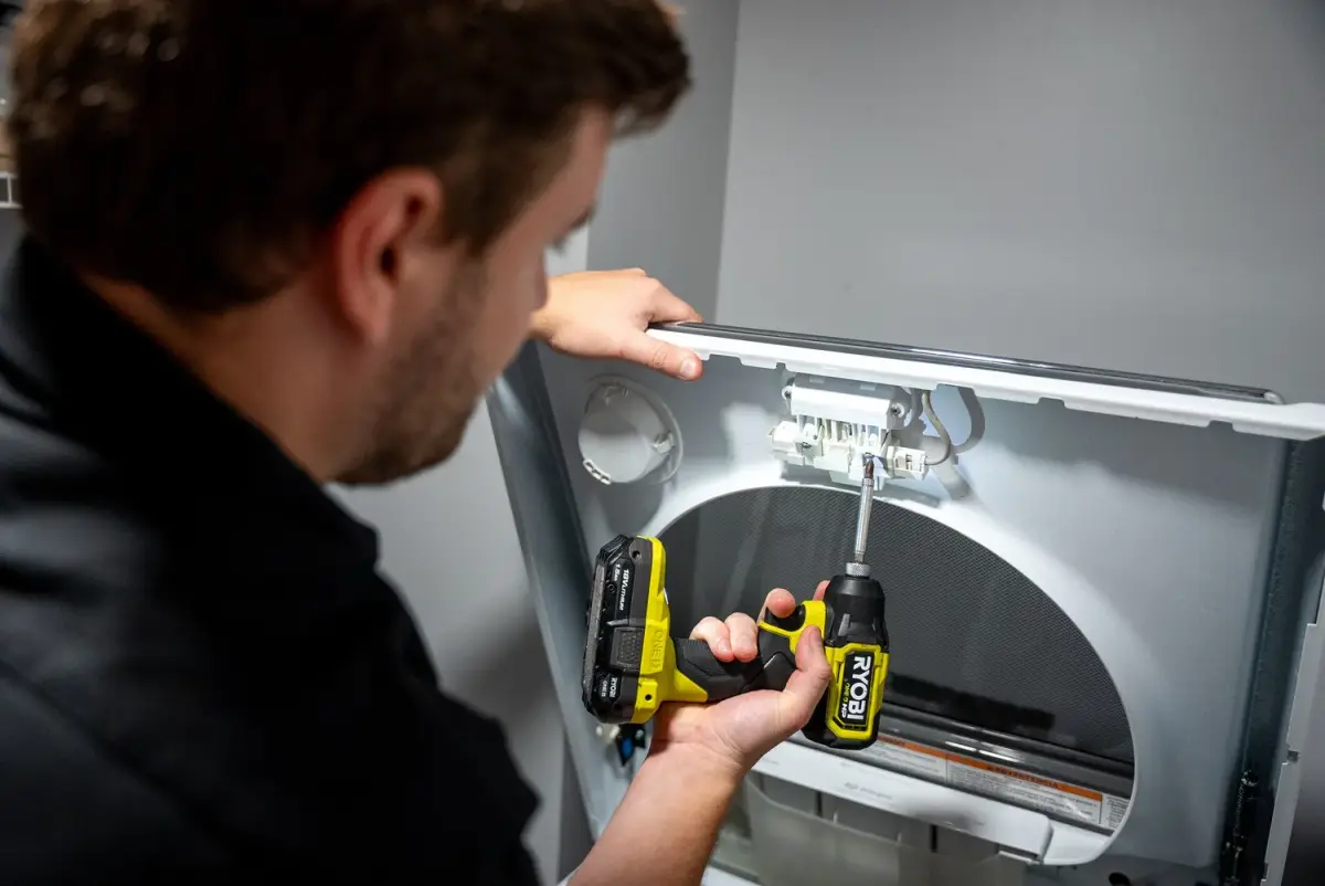 Mr. Fixer technician performing dryer repair